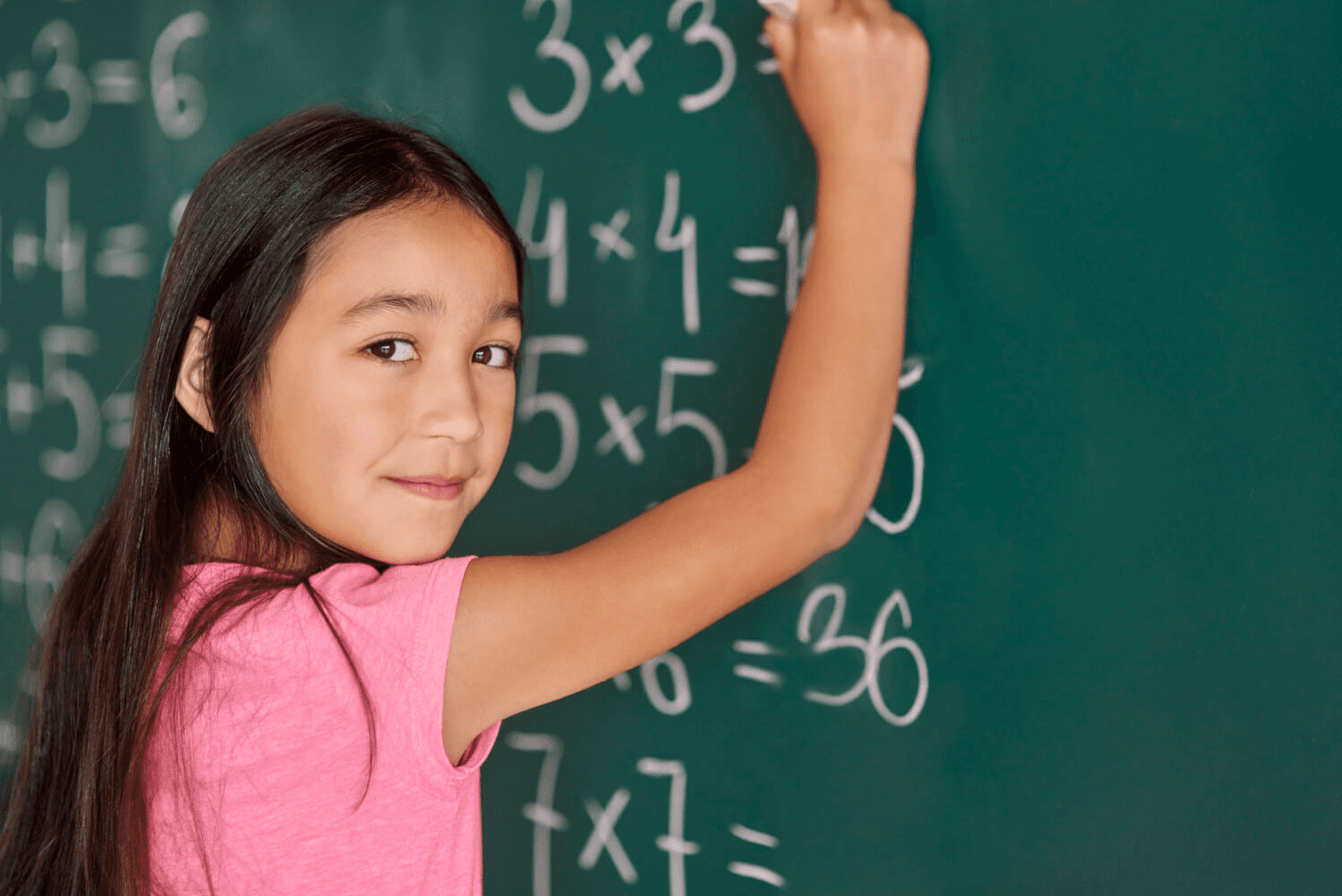 Student writing on a chalkboard